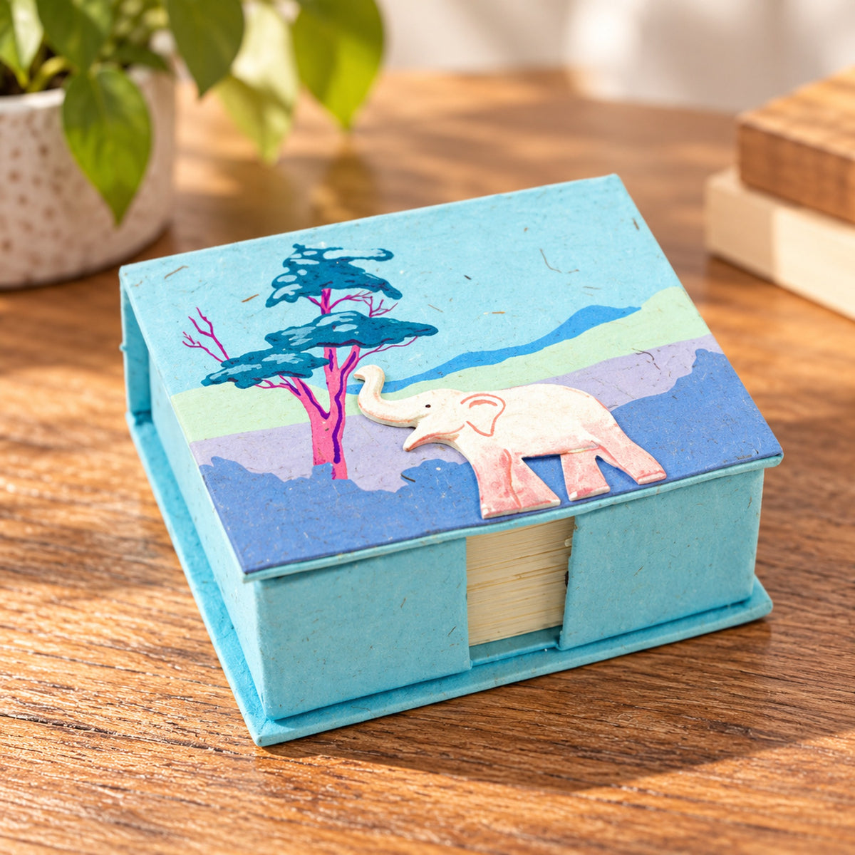 Robin's egg blue elephant note box with raised white elephant and landscape on wooden table
