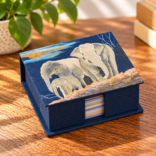 Dark blue elephant family note box with three elephants on a wooden tabletop